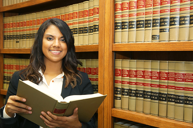 Young woman holding a law book in the law library