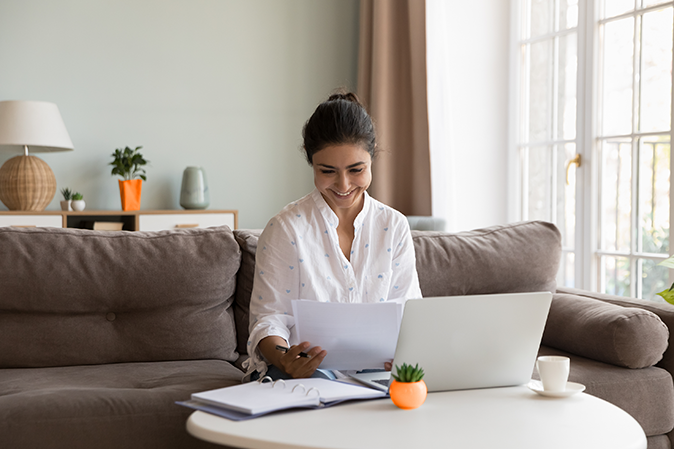 Young woman looking at admissions papers on couch