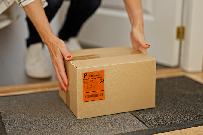 woman picking up a package outside the door