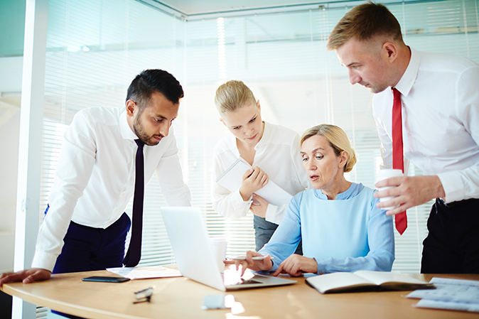 group of people working together on a laptop